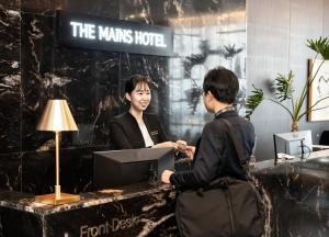 天安市The Mains Hotel的男人和女人握手在桌子上