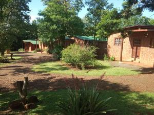 un patio con un edificio, árboles y césped en Estrella del Monte en Puerto Iguazú