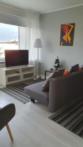 a living room with a couch and a flat screen tv at Hamina Orange Apartments Kadetti 2 in Hamina