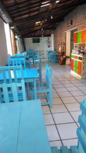 a restaurant with blue tables and blue chairs in a room at Pousada Vila Do Porto Ar Condicionado e Cafe Da Manha in Porto Seguro