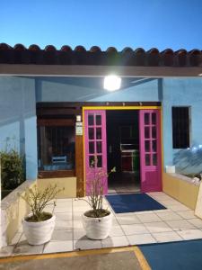 a colorful front door of a house with two potted plants at Pousada Vila Do Porto Ar Condicionado e Cafe Da Manha in Porto Seguro