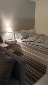 a bedroom with a bed and a lamp and a chair at Hamina Orange Apartments Kadetti 2 in Hamina