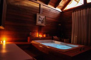 uma grande banheira num quarto com paredes de madeira em Pousada Fogo Eterno em Urubici