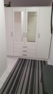 Zimmer mit weißen Schränken und gestreiftem Teppich in der Unterkunft Hamina Orange Apartments Kadetti 2 in Hamina