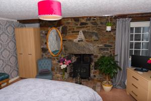 a bedroom with a stone wall with a fireplace at Stravaig B&B in Cullen