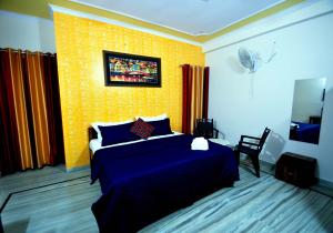 a bedroom with a bed and a yellow wall at Michael's Homestay in Jaipur
