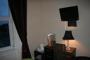 a hotel room with a desk and a tv on the wall at Royal Hotel in Girvan