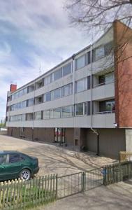 a green car parked in front of a building at Hamina Orange Apartments Kadetti 2 in Hamina