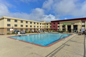 a hotel with a swimming pool in front of a building at Holiday Inn Express San Francisco Airport South, an IHG Hotel in Burlingame