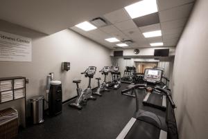 une salle de sport avec une rangée de tapis de course et de machines dans l'établissement Holiday Inn Raleigh Downtown, an IHG Hotel, à Raleigh