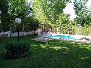 a yard with a swimming pool and a fence at Las Flores, casa del valle in Potrerillos