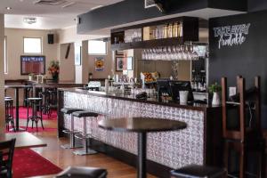 a bar in a restaurant with bar stools at Royal Derby Hotel in Melbourne