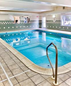 a large swimming pool with a handrail in a building at Country Inn & Suites by Radisson, Cincinnati Airport, KY in Hebron