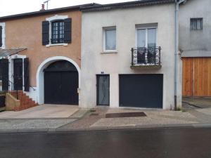 uma casa com duas portas de garagem numa rua em Maison em Damblain