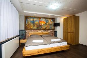 ロキトニツェ・ナト・イゼロウにあるPension Rokyのベッドルーム1室(壁に絵画が描かれたベッド1台付)