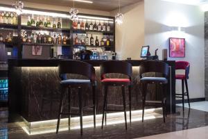 a bar with black stools and bottles of alcohol at Old Town Hotel in Timişoara