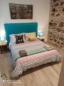 1 dormitorio con 1 cama grande y cabecero azul en El Muro de Piedra, en Toledo