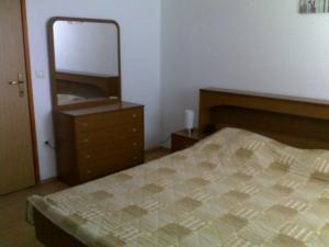 a bedroom with a bed and a dresser and a mirror at Apartments Katja in Štinjan