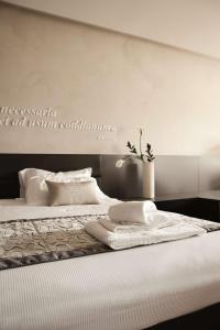 a bed with white sheets and pillows on it at Hotel Majestic in Galzignano