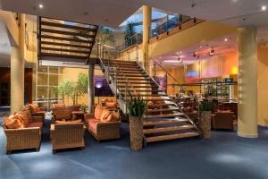 a staircase in a hotel lobby with chairs and tables at Radisson Blu Fürst Leopold Hotel in Dessau