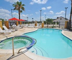 a large swimming pool at a resort with lounge chairs at Comfort Suites Shenandoah-The Woodlands in The Woodlands