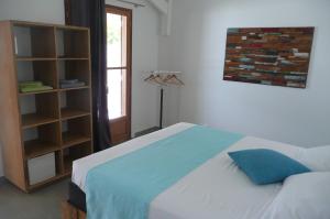 ein Schlafzimmer mit einem Bett und einem Bücherregal in der Unterkunft Douceurs Caraïbes, Gîte Papaye. in Bouillante