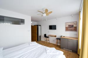 a bedroom with a white bed and a desk at Salon Win Wine Bar & Apartments in Jasło