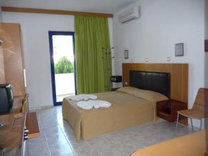 LivadiaにあるIrinoula Apartmentsのベッドルーム(ベッド1台、緑のカーテン付)