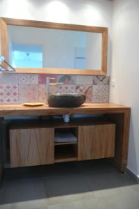- un comptoir en bois avec un miroir et un lavabo dans l'établissement Douceurs Caraïbes, Gîte Coco., à Bouillante 13 autres photos