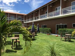 een binnenplaats met tafels en parasols voor een gebouw bij HOTEL VIRGULINO in Olho D’Água do Casado