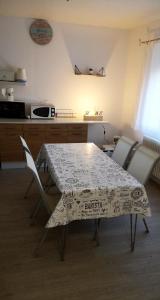 a table and chairs in a kitchen with a table and a microwave at Hôte "Il était une fois" in Hesdin