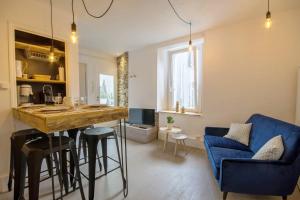 cocina y sala de estar con bar y sofá azul en TY LAUMANN petite maison jardin sur le port de vannes avec Parking souterrain, en Vannes