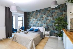 1 dormitorio con 1 cama con almohadas azules en King4You Apartments, en Wroclaw
