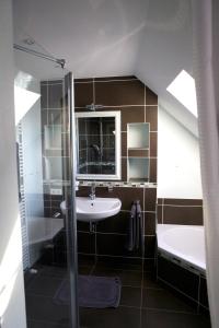 ein Badezimmer mit einem Waschbecken, einer Dusche und einer Badewanne in der Unterkunft Time2Lounge in Osnabrück