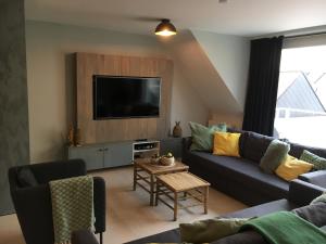 a living room with a couch and a tv at ABC Apartment in Blankenberge