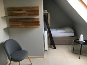 sypialnia z łóżkiem i krzesłem na poddaszu w obiekcie ABC Apartment w mieście Blankenberge