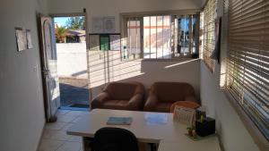 een kamer met 2 stoelen, een tafel en een raam bij Pousada Emanuel in Araranguá