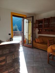 a living room with a couch and a sliding glass door at Il Nido B&B in Villa Dalegno