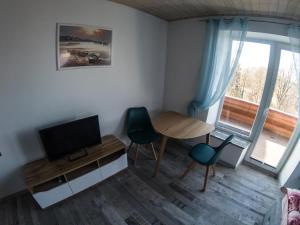 ロンデク・ズドルイにあるWilla Relaksのリビングルーム(テレビ、テーブル、椅子付)