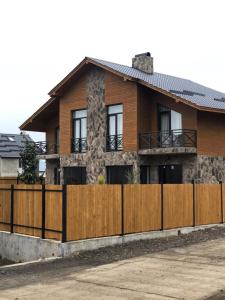 a house with a wooden fence in front of it at Cottage Near Didveli, Bakuriani - котедж в Бакуриани in Bakuriani