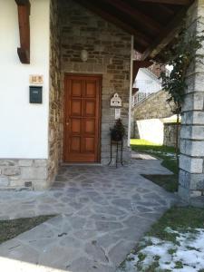 uma porta da frente de uma casa com uma parede de pedra em Il Nido B&B em Villa dʼAllegno