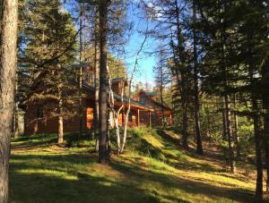 una cabaña de madera en el bosque con árboles en The Ridge At Glacier - Luxury Cabins en Coram