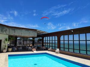 a kite is flying over a swimming pool at Flat Pasárgada III (apt 116) in Vila Velha