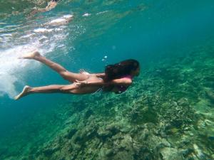 a woman is swimming in the water at Hotel Isla Del Pirata in Isla del Pirata