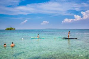 a group of people on surfboards in the water at Hotel Isla Del Pirata in Isla del Pirata