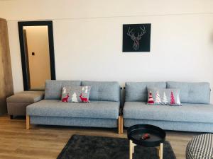 ein Wohnzimmer mit 2 Sofas und einem Tisch in der Unterkunft SKI-Art Apartments in Szczyrk