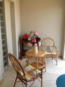 バスティアにあるVilla Pergolaの椅子2脚とテーブル(花付)が備わるお部屋