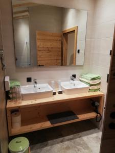 Baño con 2 lavabos y espejo en Gasthaus Goglhof, en Fügenberg