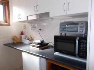 a kitchen counter with a microwave and a toaster oven at Costa Plenti Southend BnB in Southend