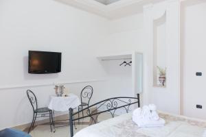 een slaapkamer met een tafel en stoelen en een televisie bij Camera Ardea in Aversa